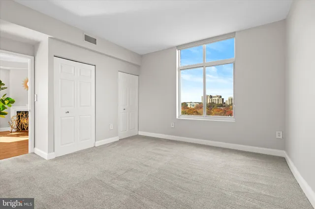 an empty room with windows and closet