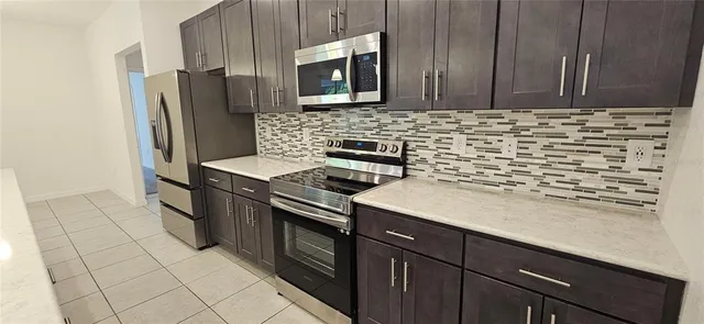 a kitchen with stainless steel appliances a stove microwave and refrigerator