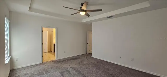 an empty room with closet and a chandelier fan