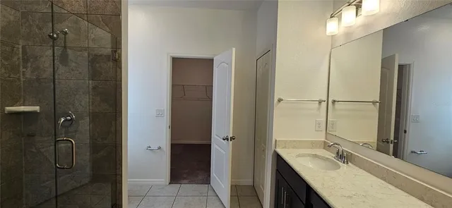 a bathroom with a granite countertop sink a mirror and shower