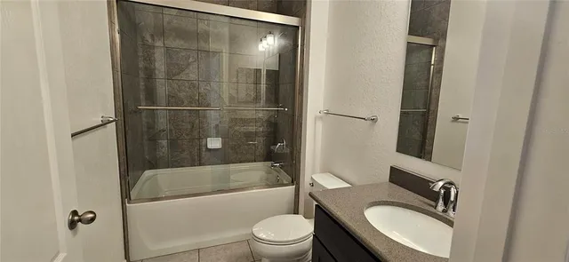 a bathroom with a granite countertop toilet sink and shower