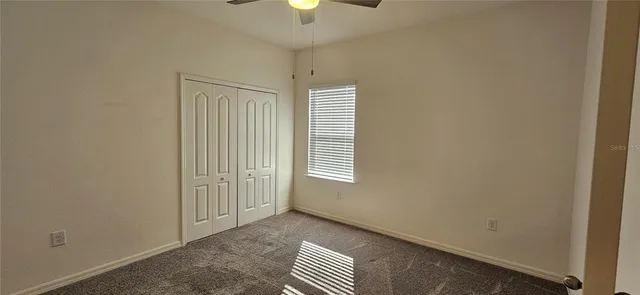 an empty room with windows and closet