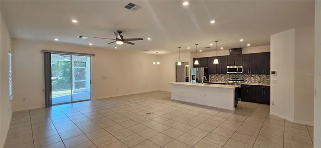 a large white kitchen with a large counter top and stainless steel appliances