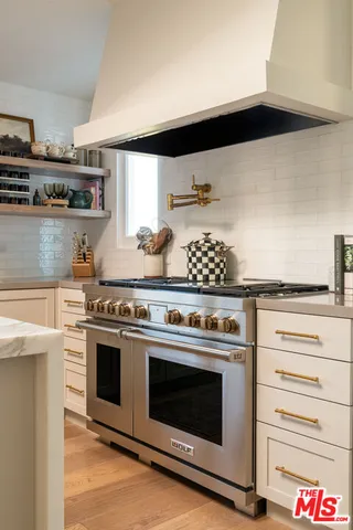 a stove top oven sitting inside of a kitchen