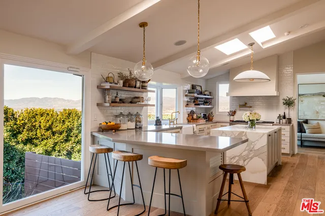 a kitchen with stainless steel appliances granite countertop a stove a refrigerator a oven a sink with island chairs and wooden floor