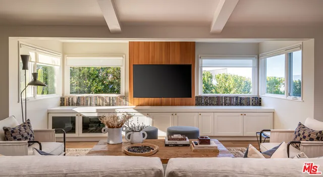 a living room with fireplace furniture and a large window
