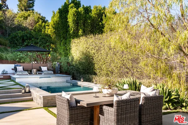 a view of backyard with swimming pool and outdoor seating