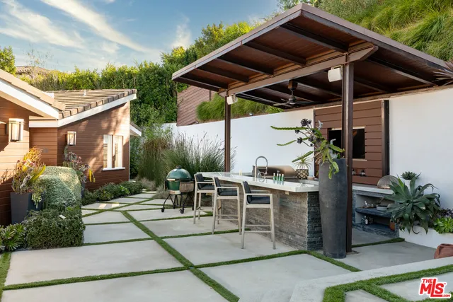 a view of a patio with table and chairs potted plants