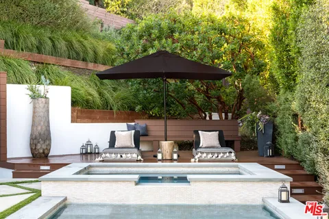 a view of a patio with table and chairs under an umbrella