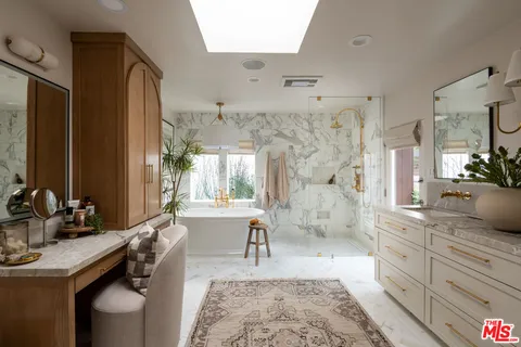 a spacious bathroom with a granite countertop sink a toilet a mirror and shower
