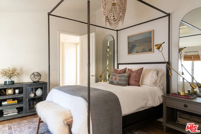 a bedroom with a bed mirror and a window