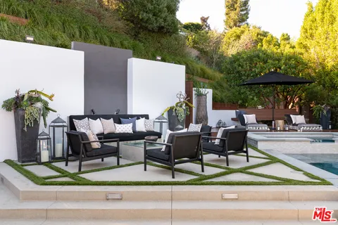 a view of backyard with outdoor seating and plants
