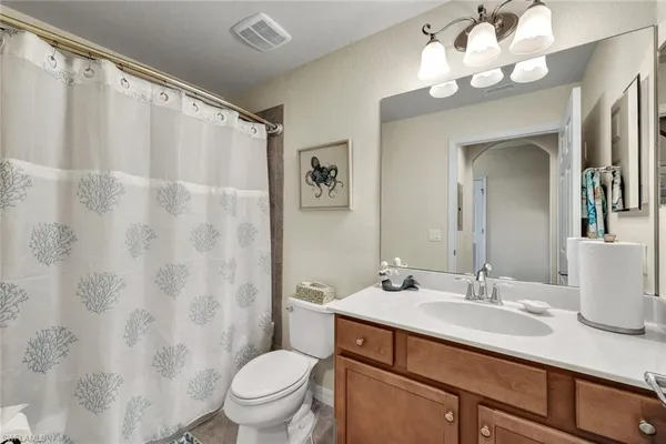 a bathroom with a granite countertop sink a toilet and a mirror