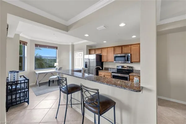 a kitchen with stainless steel appliances kitchen island granite countertop a stove a sink a dining table and chairs