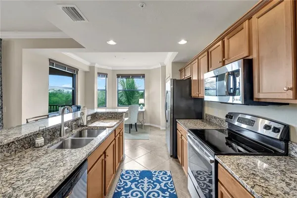 a kitchen with stainless steel appliances granite countertop a sink stove and refrigerator