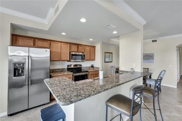 a kitchen with granite countertop a counter space cabinets stainless steel appliances and a counter top space