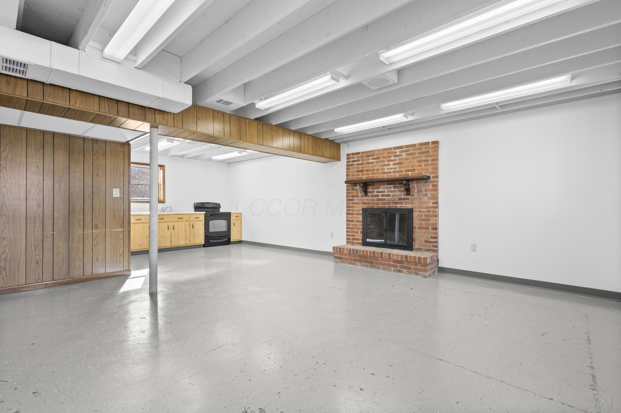 6650 Kilbourne Road Sunbury, OH 43074 - Photo 31 of 49 Lower-level Family Room w/kitchen area & Woodburning Fireplace