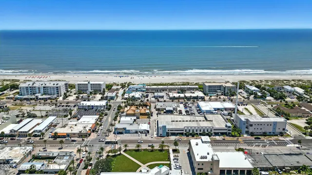 an aerial view of residential houses with outdoor space and ocean view