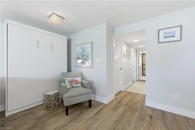 a hallway with wooden floor and a bed