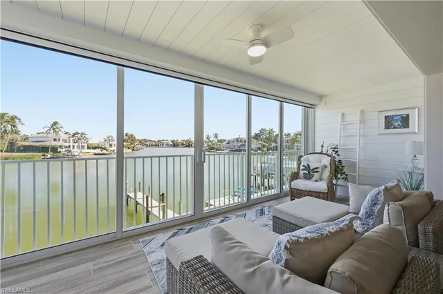 a bed sitting in a balcony next to a large window