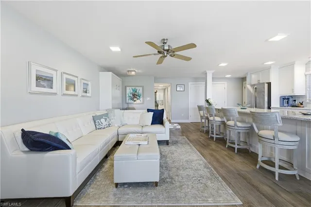 a living room with furniture and a dining table with kitchen view
