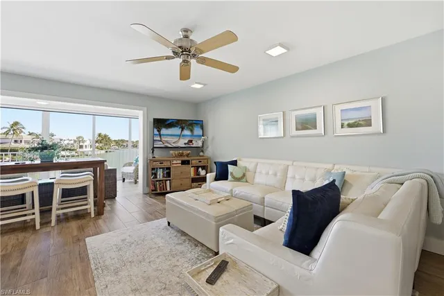 a living room with furniture a ceiling fan and a window