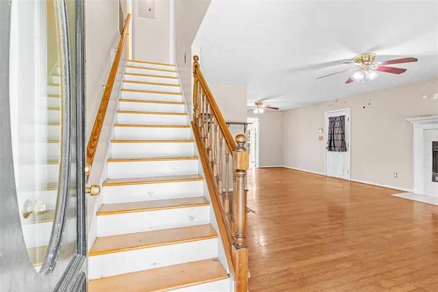 a view of staircase with white walls and wooden floor