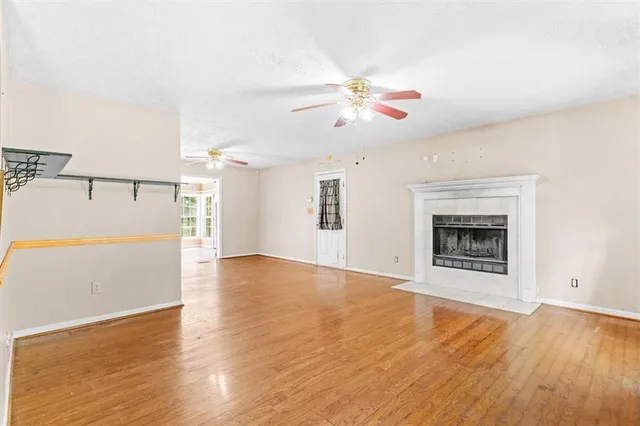 a view of an empty room with window and wooden floor