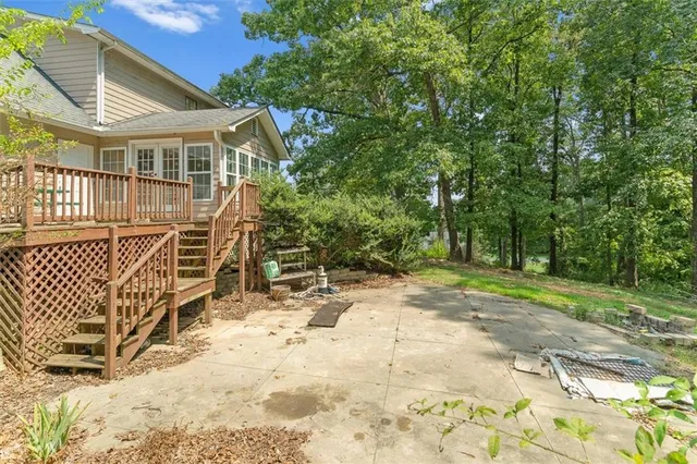a white house with a large tree and wooden fence