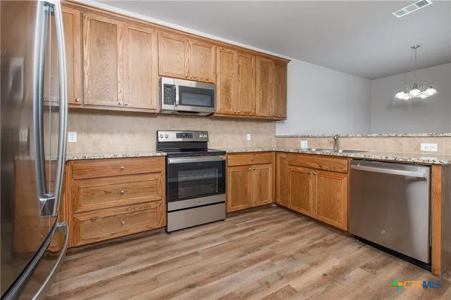 a kitchen with stainless steel appliances granite countertop a stove and a microwave