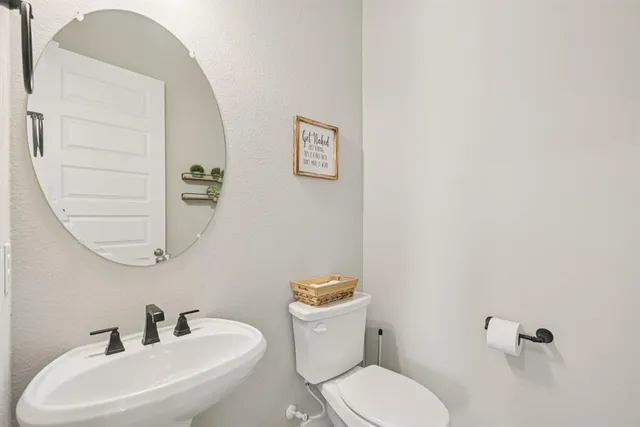 a bathroom with a toilet sink and mirror