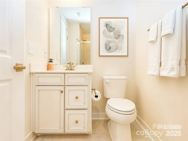 a bathroom with a toilet a sink a vanity and mirror