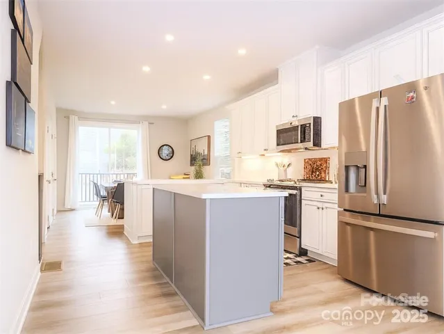 a kitchen with refrigerator cabinets and wooden floor