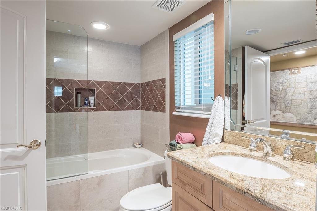 445 3rd Avenue South, Unit 102 Naples, FL 34102 - Photo 13 of 26 a bathroom with a granite countertop tub sink and mirror