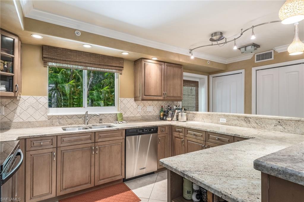 445 3rd Avenue South, Unit 102 Naples, FL 34102 - Photo 2 of 26 a kitchen with a sink window and cabinets