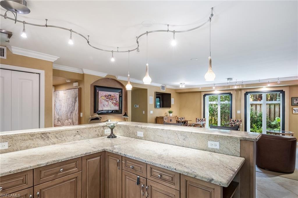 445 3rd Avenue South, Unit 102 Naples, FL 34102 - Photo 4 of 26 a kitchen with granite countertop a sink and a large window