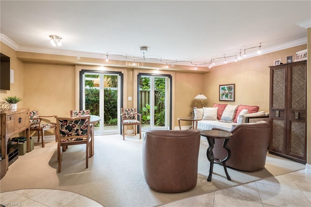 445 3rd Avenue South, Unit 102 Naples, FL 34102 - Photo 5 of 26 a living room with furniture and large windows