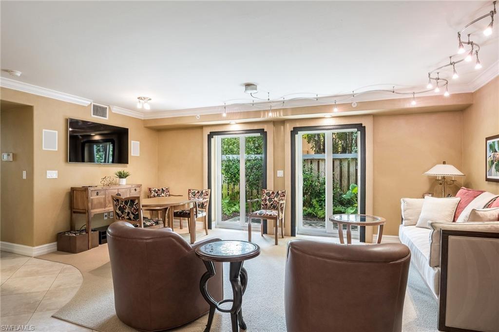 445 3rd Avenue South, Unit 102 Naples, FL 34102 - Photo 6 of 26 a living room with fireplace furniture and a flat screen tv