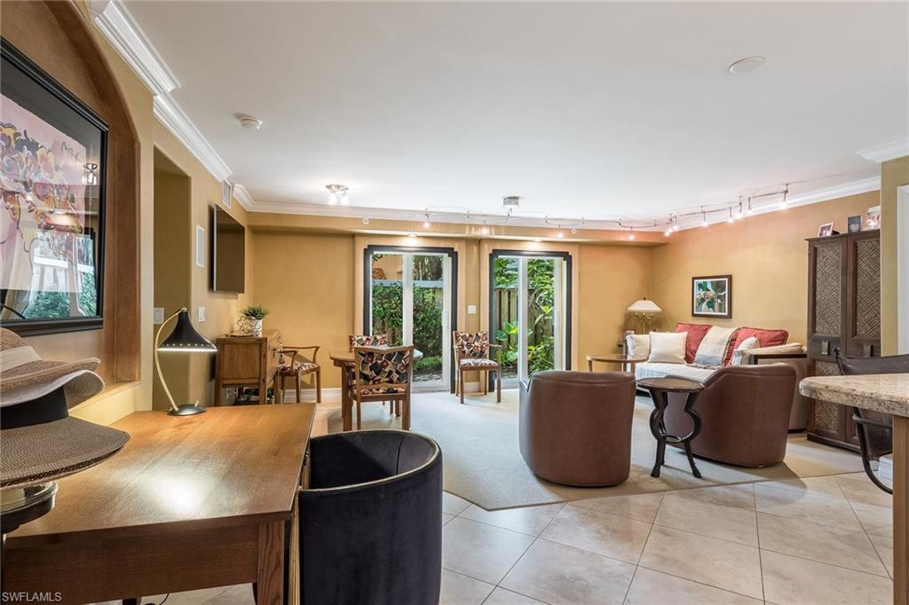 445 3rd Avenue South, Unit 102 Naples, FL 34102 - Photo 8 of 26 a living room with furniture and a large window