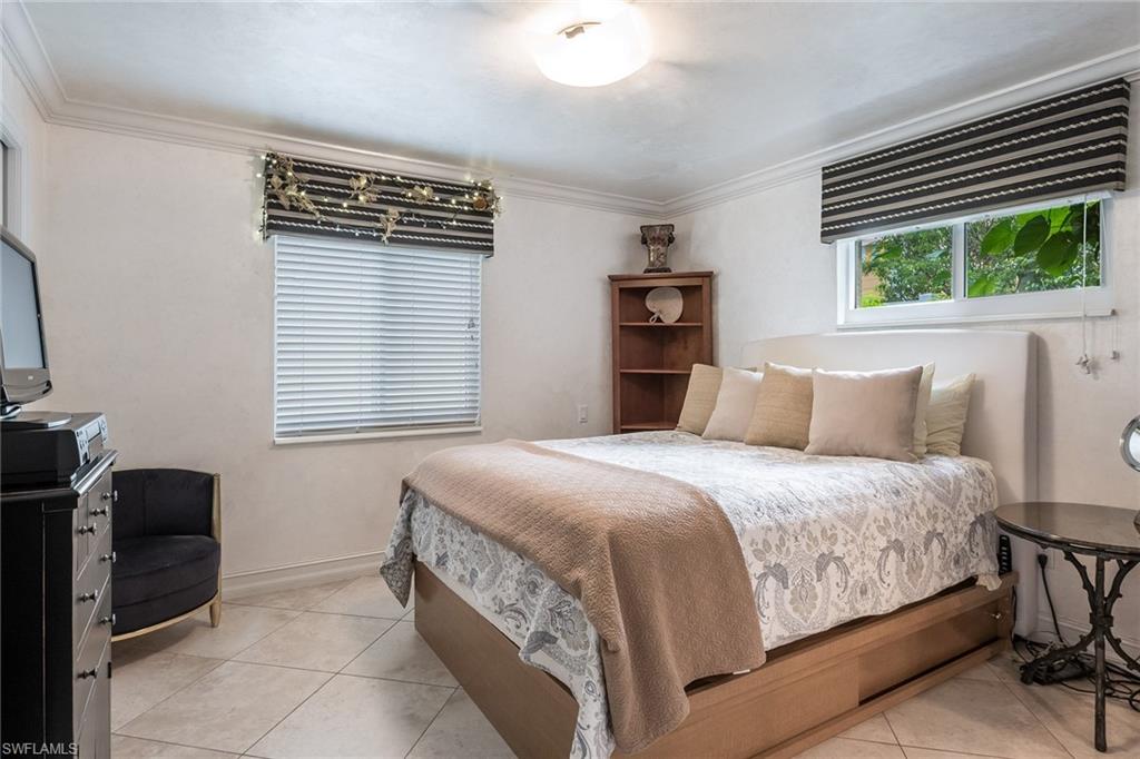 445 3rd Avenue South, Unit 102 Naples, FL 34102 - Photo 9 of 26 a bedroom with a bed and a window