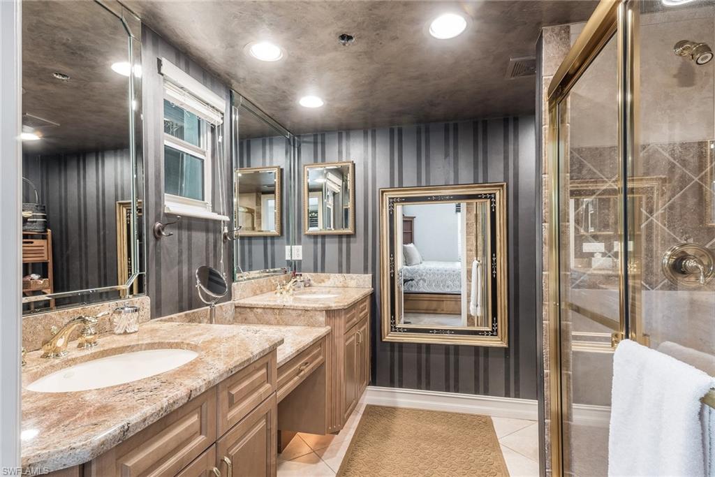 445 3rd Avenue South, Unit 102 Naples, FL 34102 - Photo 10 of 26 a bathroom with a granite countertop sink and a mirror