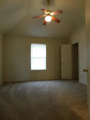 an empty room with a window and a ceiling fan
