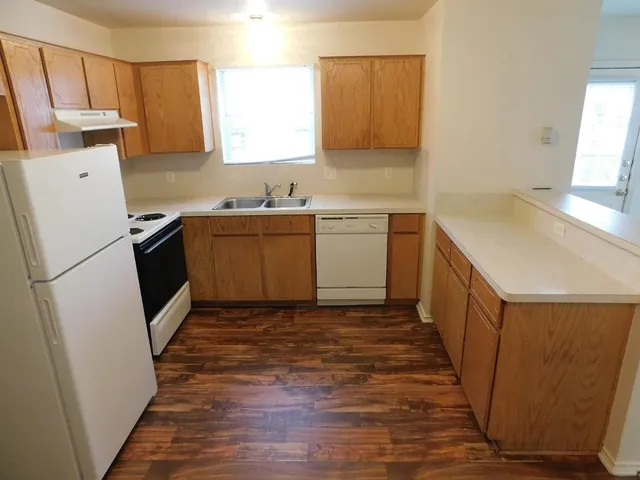 a kitchen with a sink a refrigerator a microwave and cabinets
