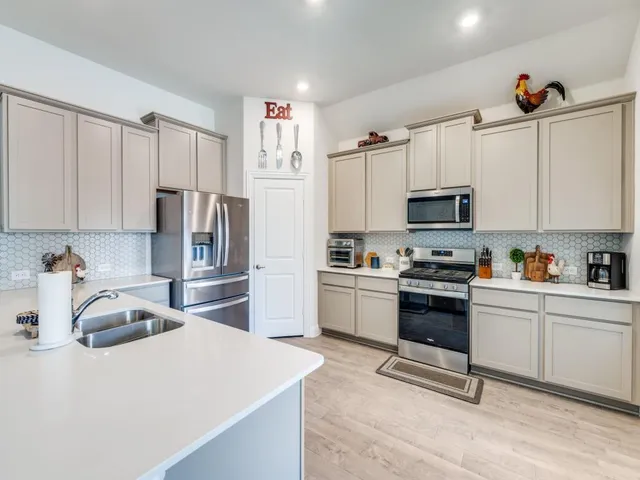 a kitchen with white cabinets and stainless steel appliances