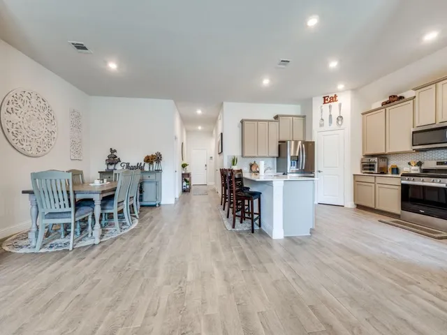 a kitchen with kitchen island granite countertop a sink a stove and cabinets