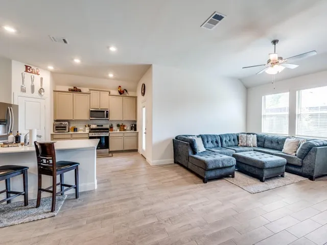 a kitchen with stainless steel appliances kitchen island granite countertop a table and chairs in it