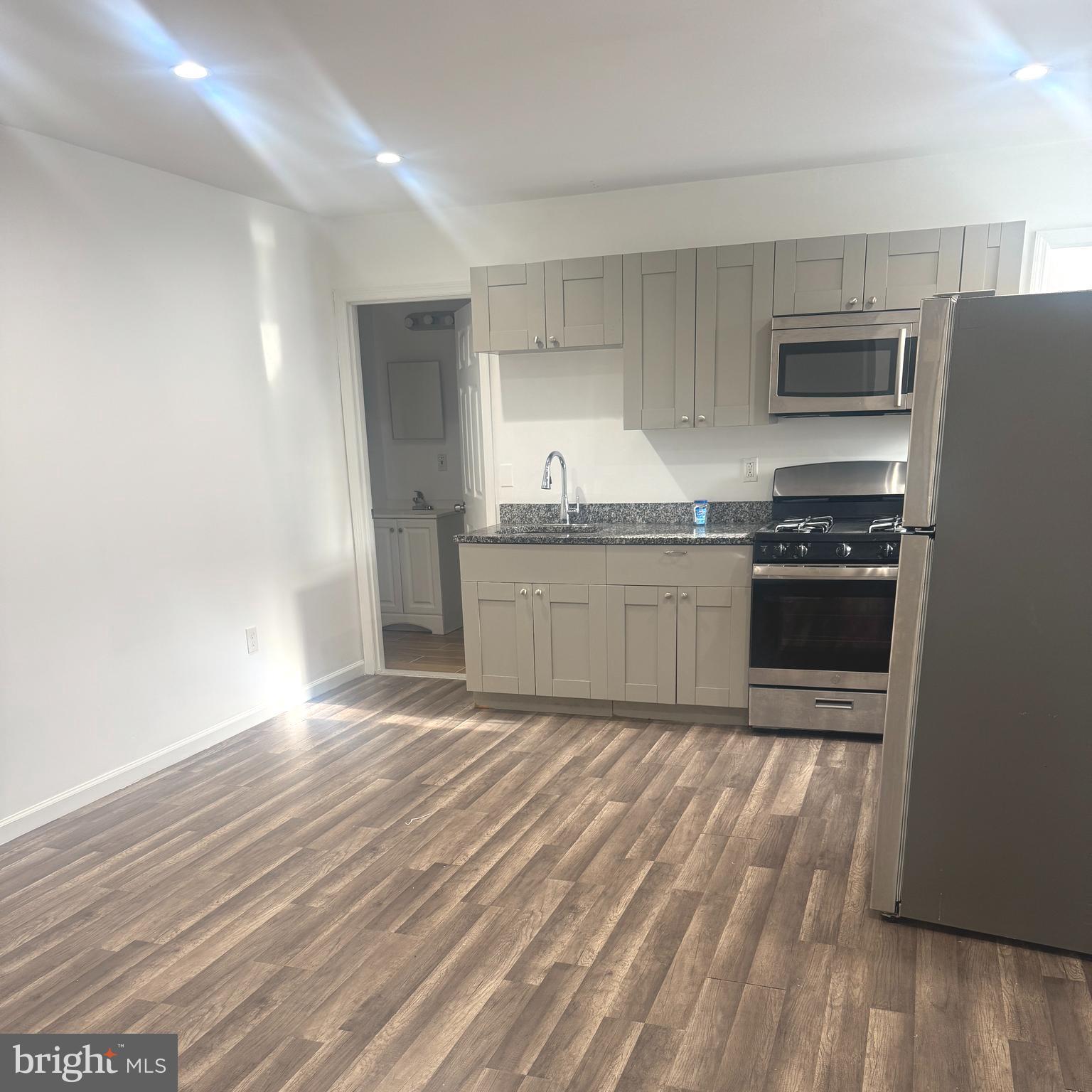 a kitchen with stainless steel appliances granite countertop a stove a sink and a refrigerator