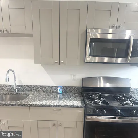 a kitchen with granite countertop a stove and a sink