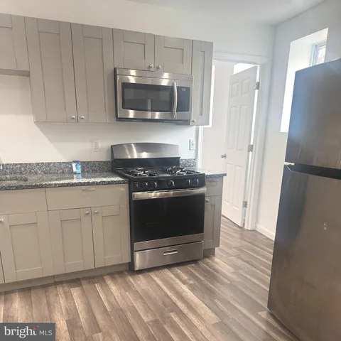 a kitchen with granite countertop white cabinets and stainless steel appliances