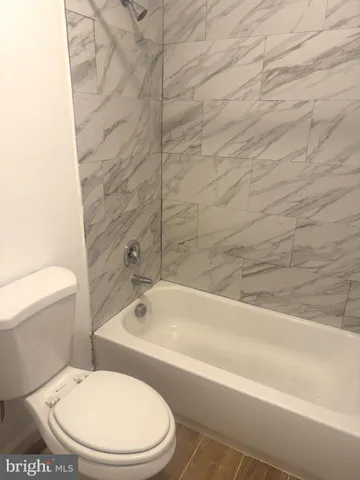 a white toilet and tub sitting next to a bathroom sink